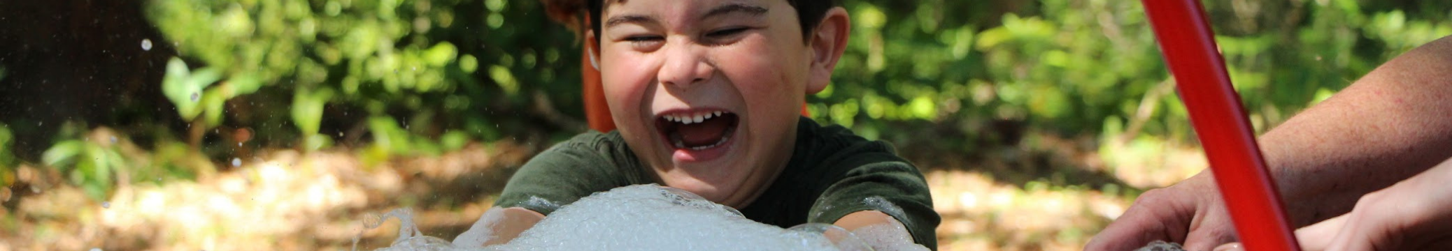 child smiling with hands in bubbles