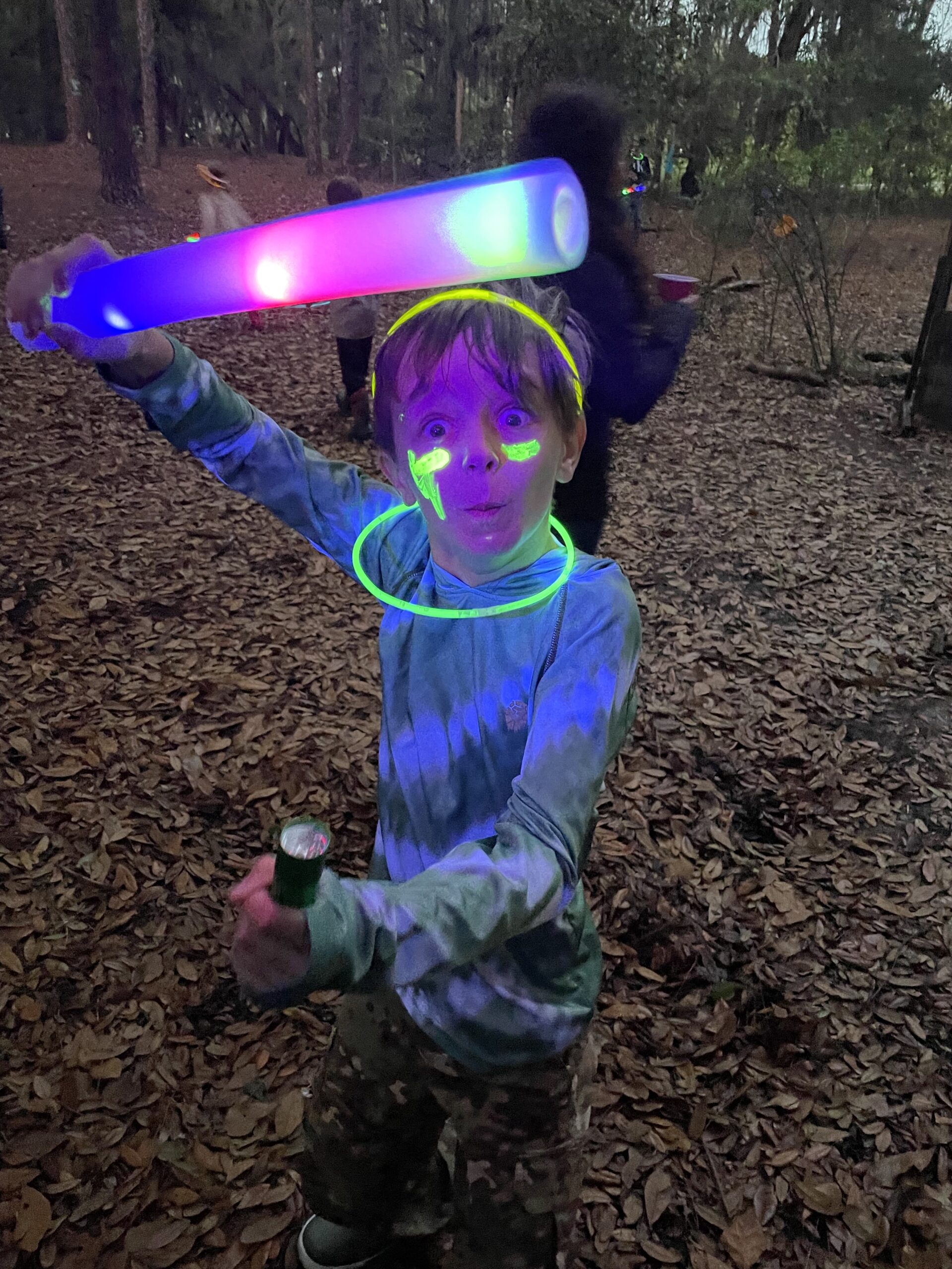 child with glow necklace at Treeline birthday glow party