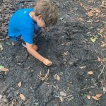 child writing in the dirt