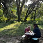 child at picnic table outdoors