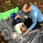occupational therapist supporting a child in position in a tarp
