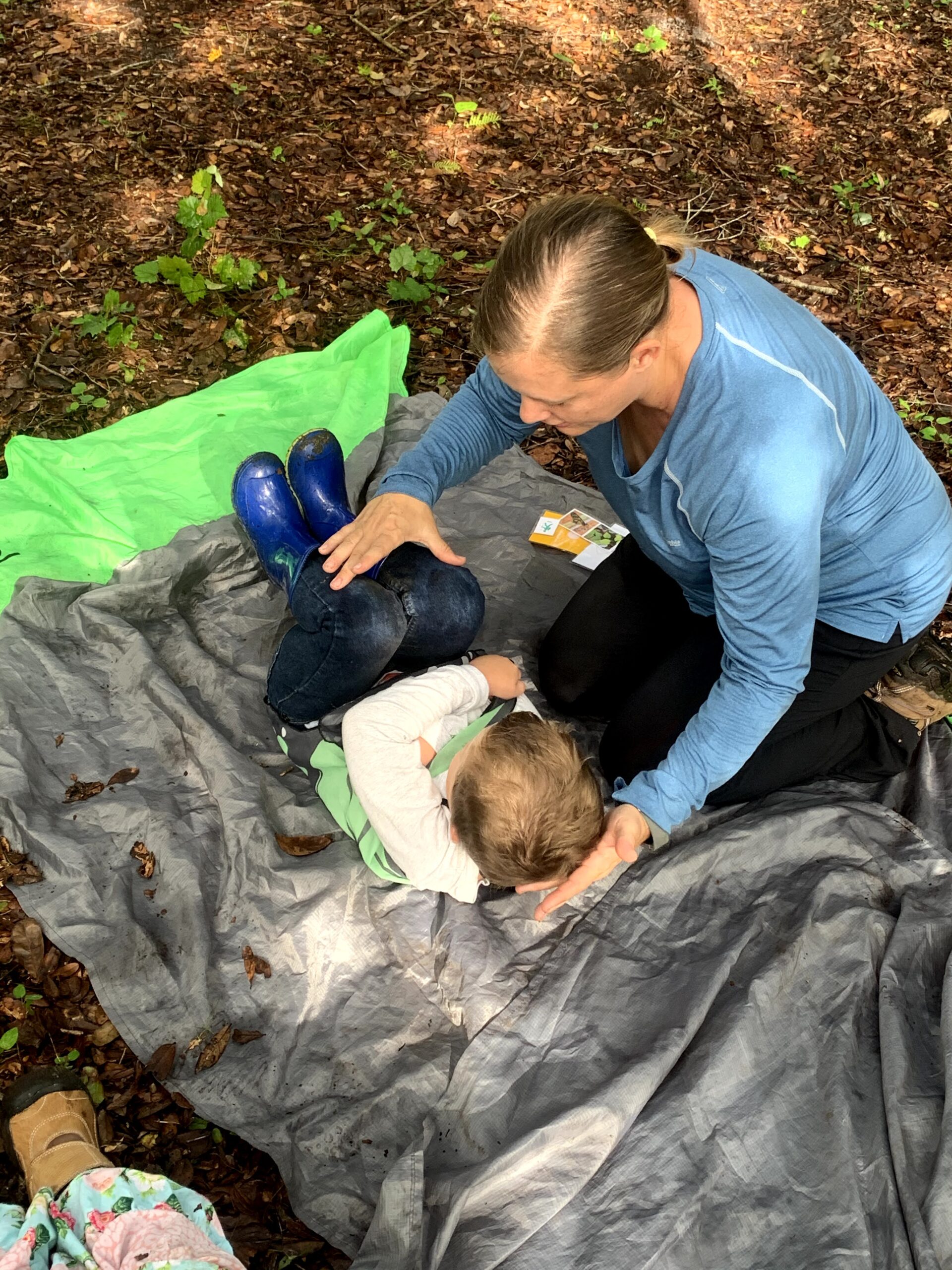 occupational therapist supporting a child in position in a tarp