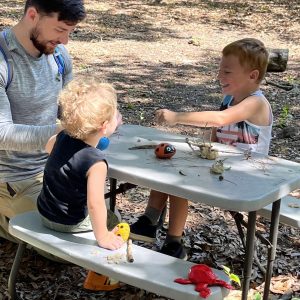 OT Student working with siblings at picnic table