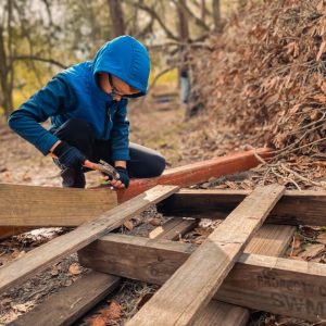 child hammering wood together