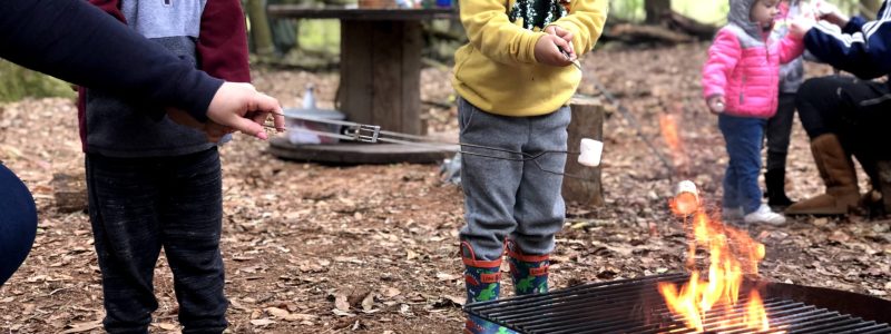 young children cooking over the fire