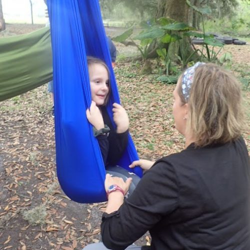Occupational Therapist supporting a child on a swing for vestibular input