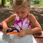 girl peeling carrot with vegetable peeler